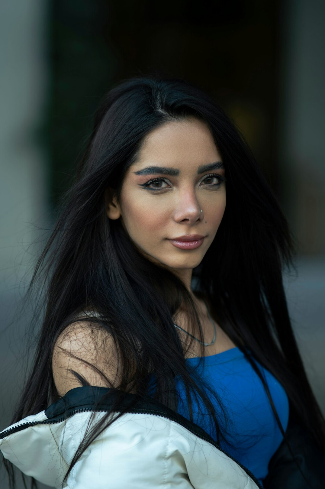 Portrait of a woman with long dark hair looking at camera